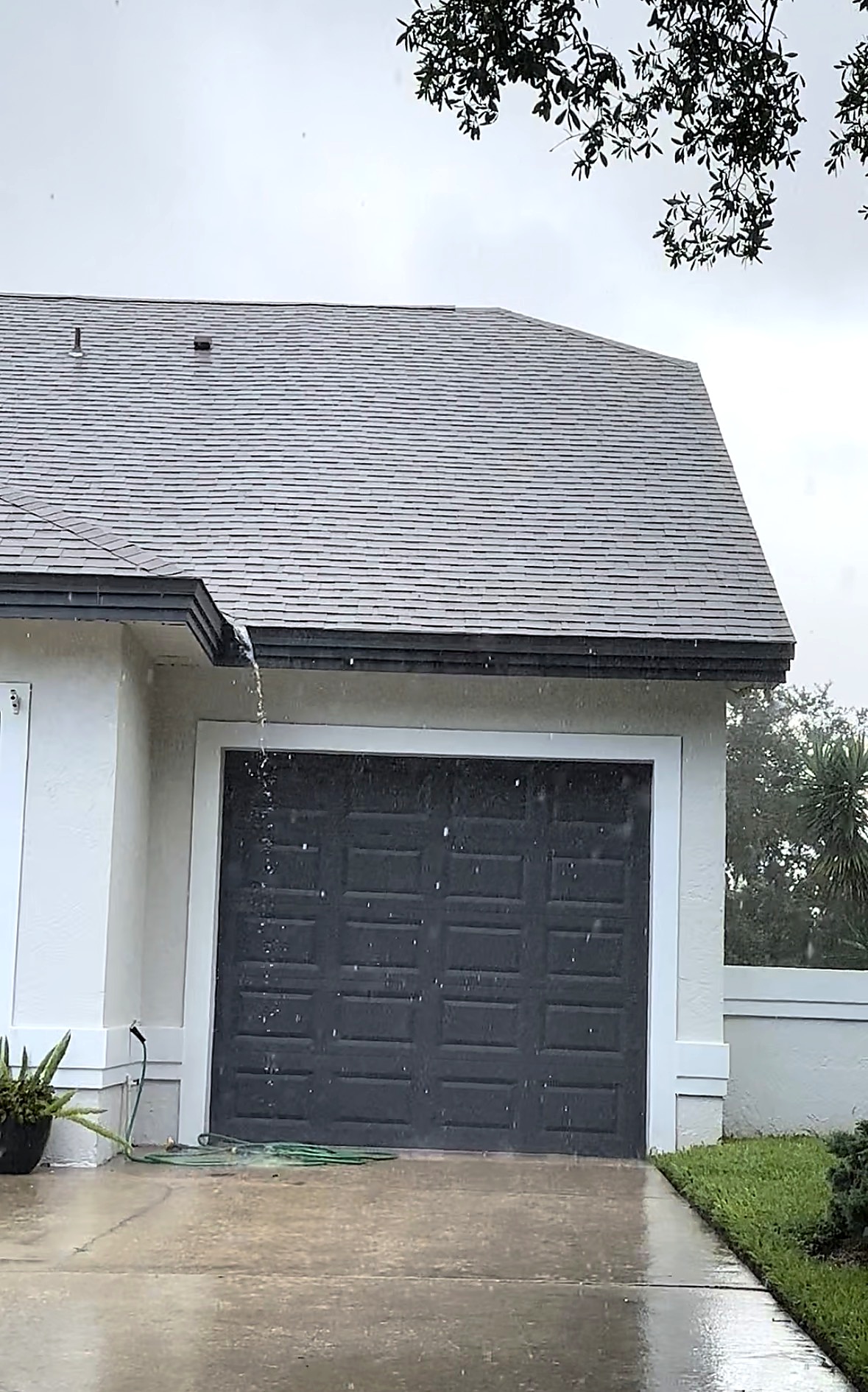 Heavy roof runoff overflowing near a roof valley during a Central Florida rainstorm